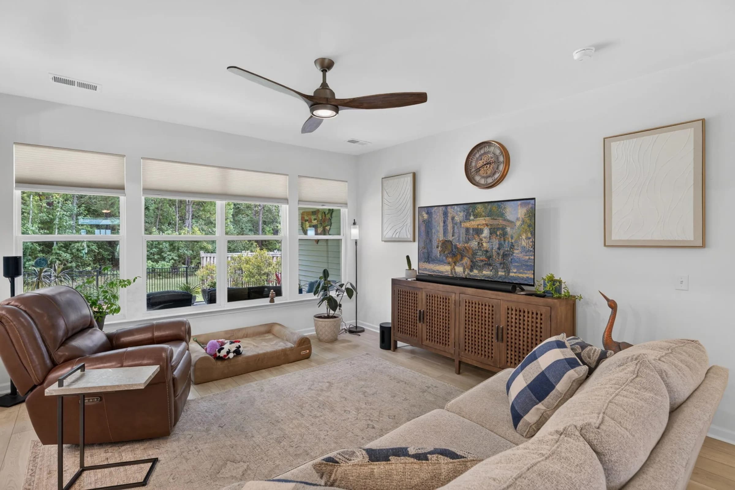 Wall-to-wall windows framing wooded views in the living room at 201 Palfrey Drive