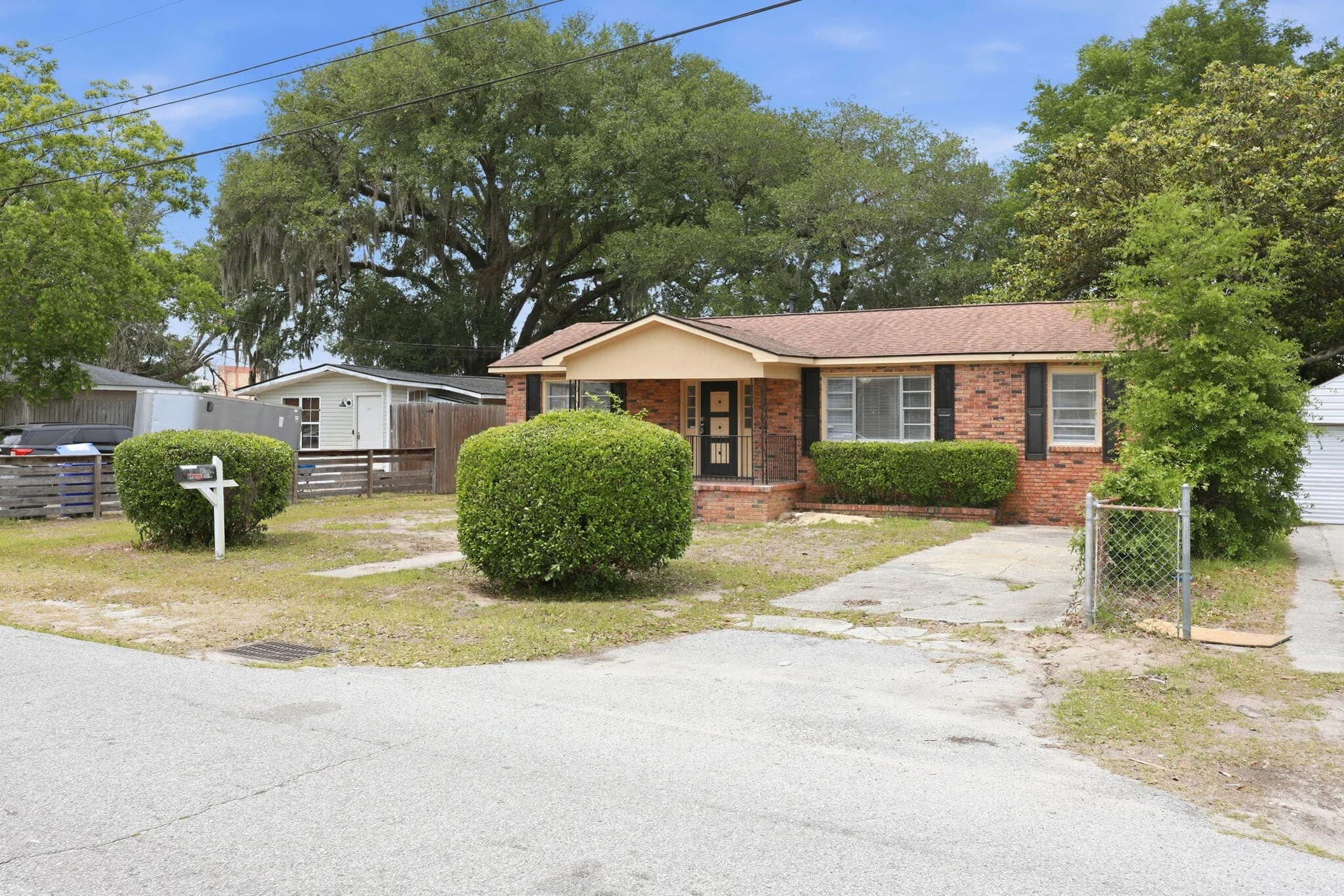 Front of the home beneath the oaks